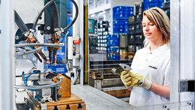 Mitarbeiterin von Martin Metallbau in Arbeitskleidung an Maschine