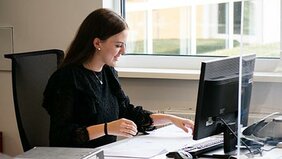 Junge Frau im Büro arbeitet am Computer