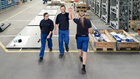 Junge Mitarbeitende der Firma Dietze und Schell begegnen sich in einer Industriehalle