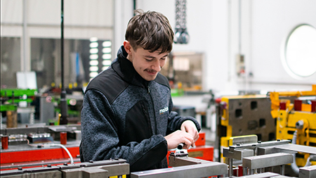 Werkzeugmechaniker arbeitet an Werkbank